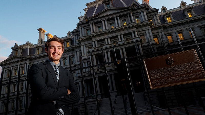 Student pauses outside of Eisenhower Executive Office Building in Washington, D.C.